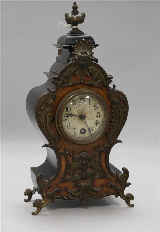 A German mantel clock in carved burr walnut and ebonised shaped case with gilt metal mounts